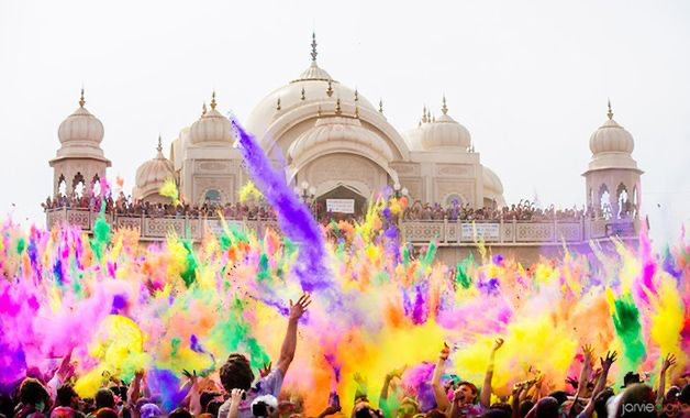 Multidão coberta de tintas coloridas celebrando o festival Holi, em Nandgaon, na Índia